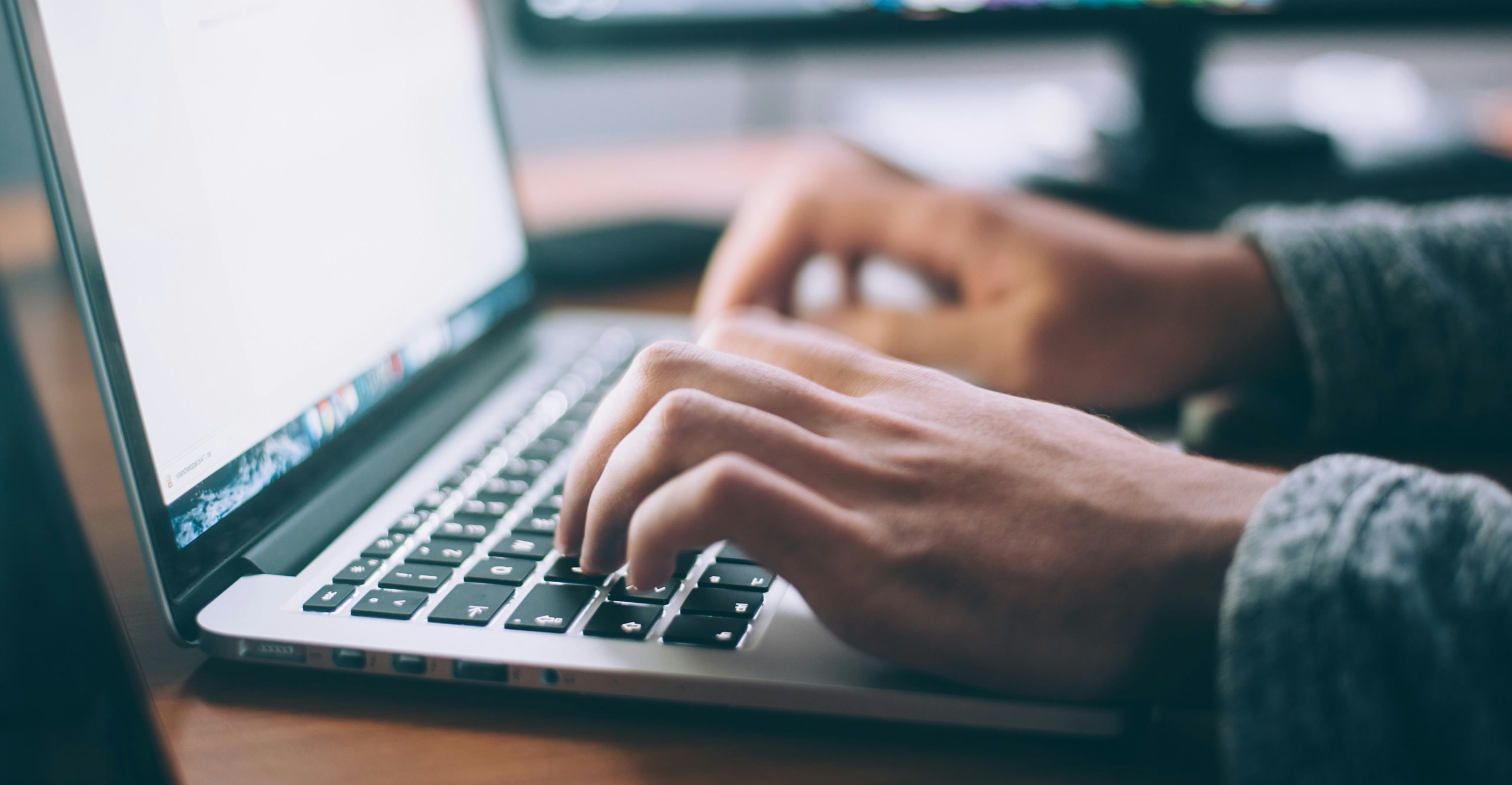 Hände tippen auf einer Laptop-Tastatur