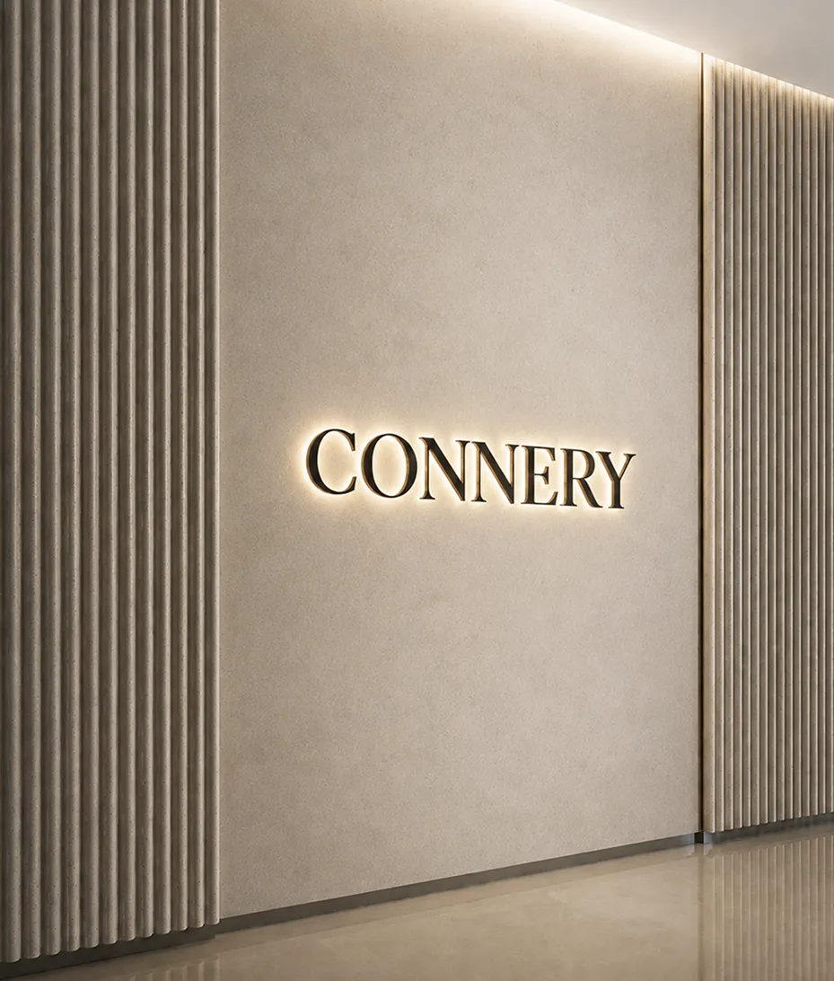 Minimalist interior wall with vertical ridges and the backlit word CONNERY in the center.