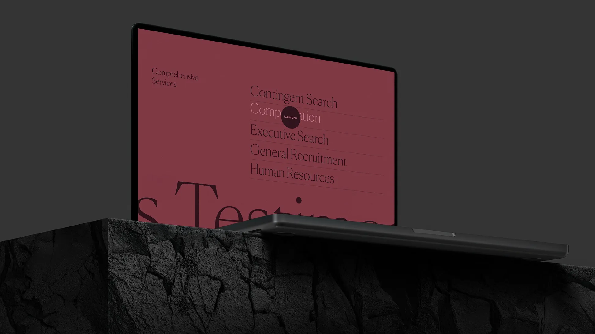 Laptop with a maroon screen showing a list of services including Contingent and Executive Search.