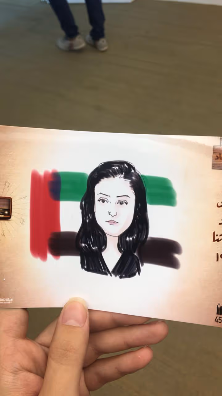 Hand-drawn portrait of a woman displayed on a card featuring the UAE flag colors and Arabic calligraphy.