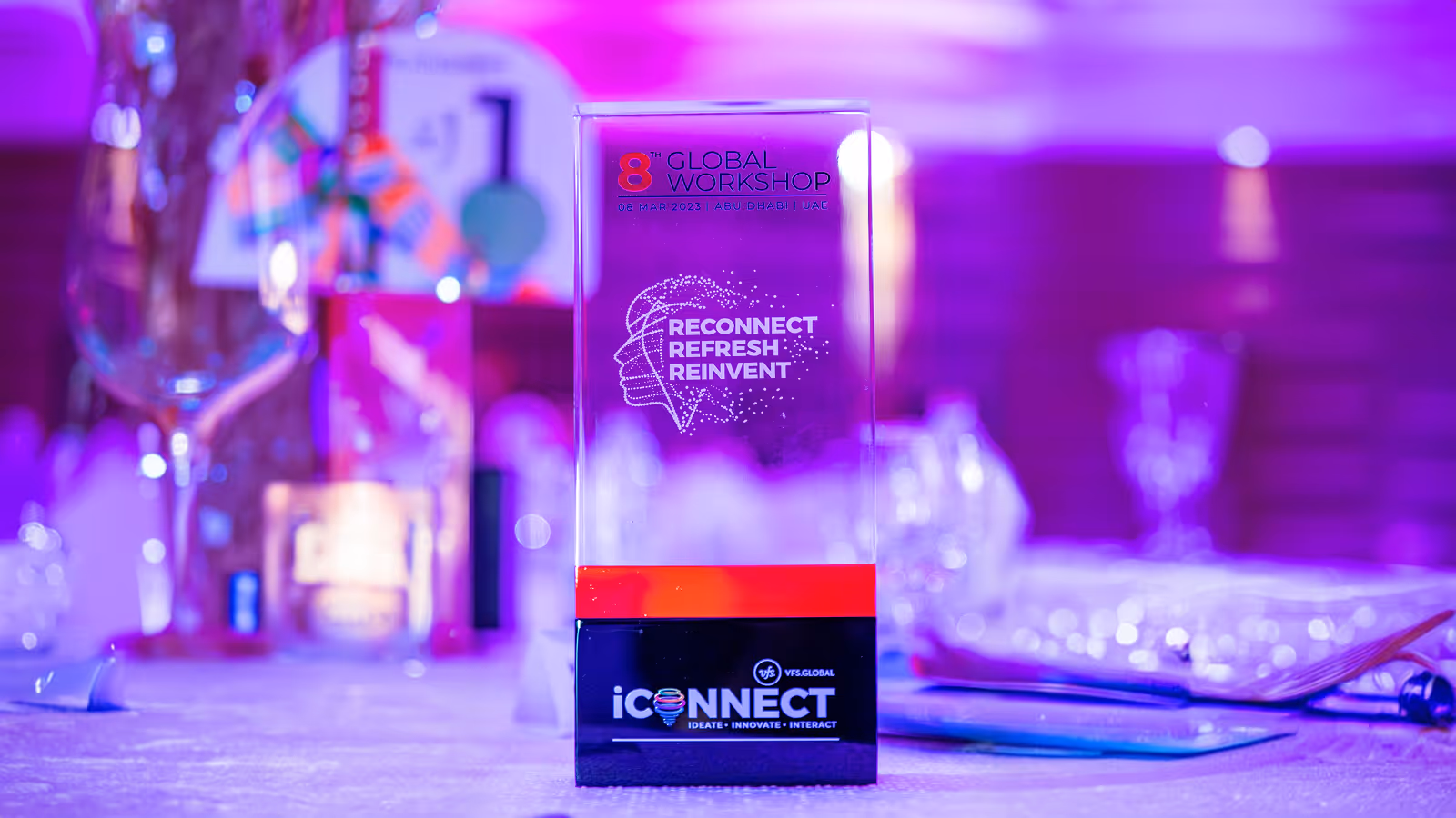 VFS Global iCONNECT 8th Global Workshop stage setup in Abu Dhabi, featuring illuminated event branding, a large digital backdrop, and a branded reception podium.