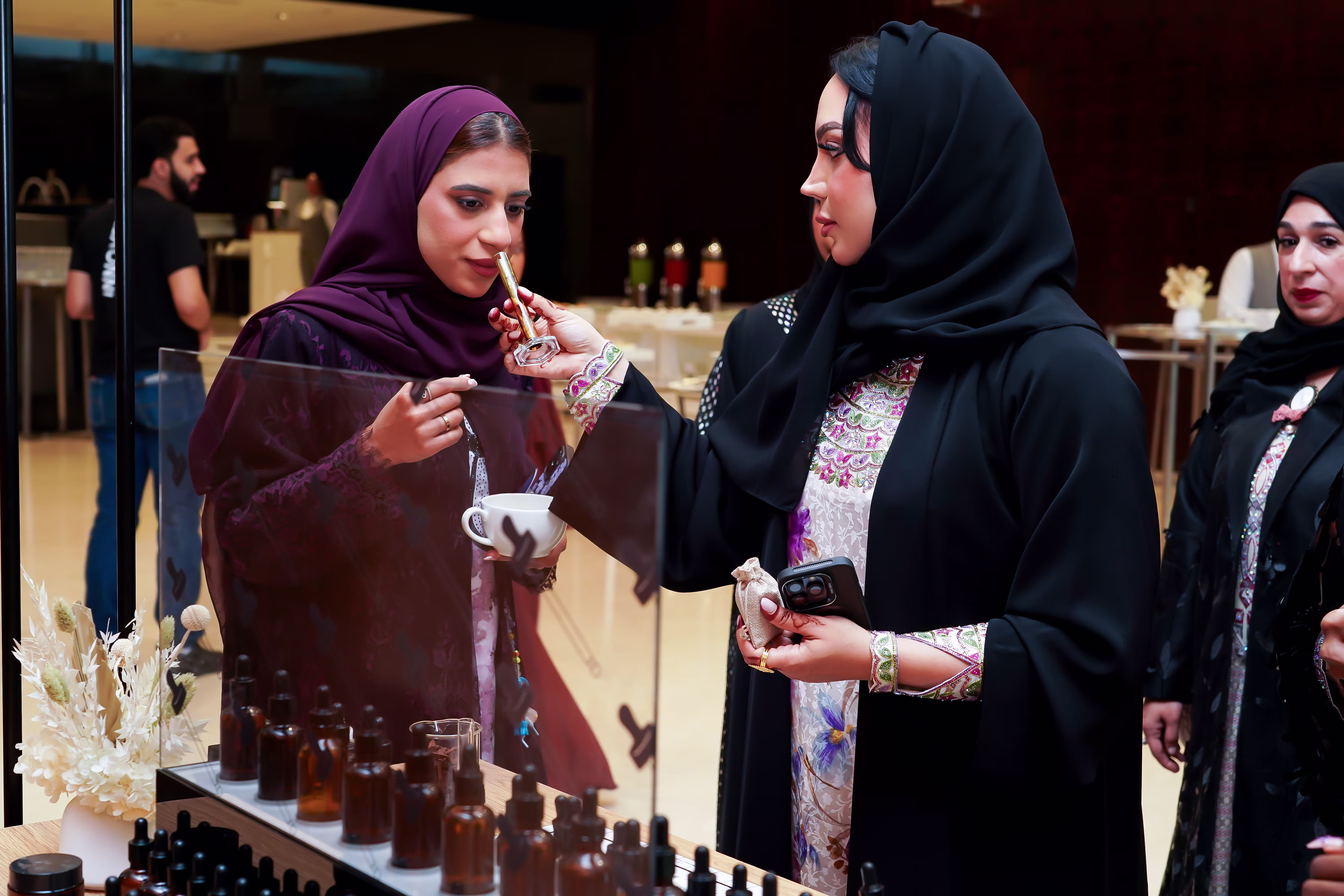 Women exploring beauty products at an Emirati Women’s Day event.