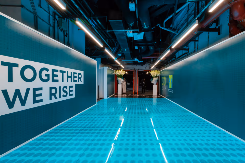 Event corridor featuring “Together We Rise” branding.