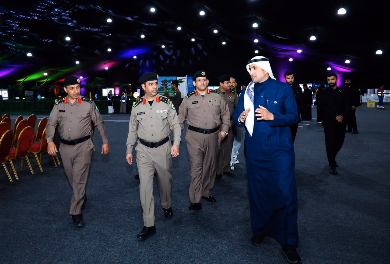Emirati officials touring an indoor event exhibition.