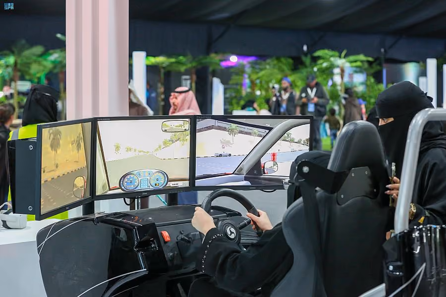 Women using a driving simulator at an interactive exhibition.