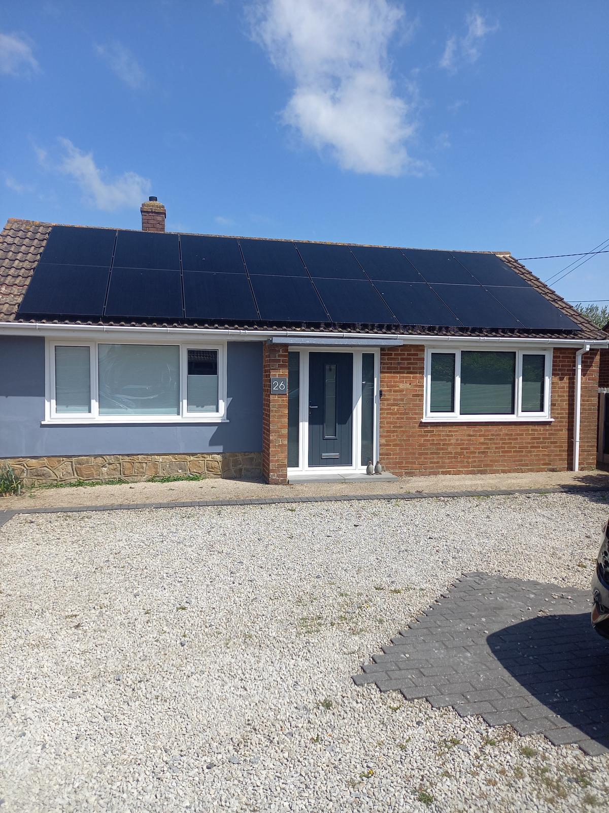 A bungalow with solar panels fitted across the full roof slope.