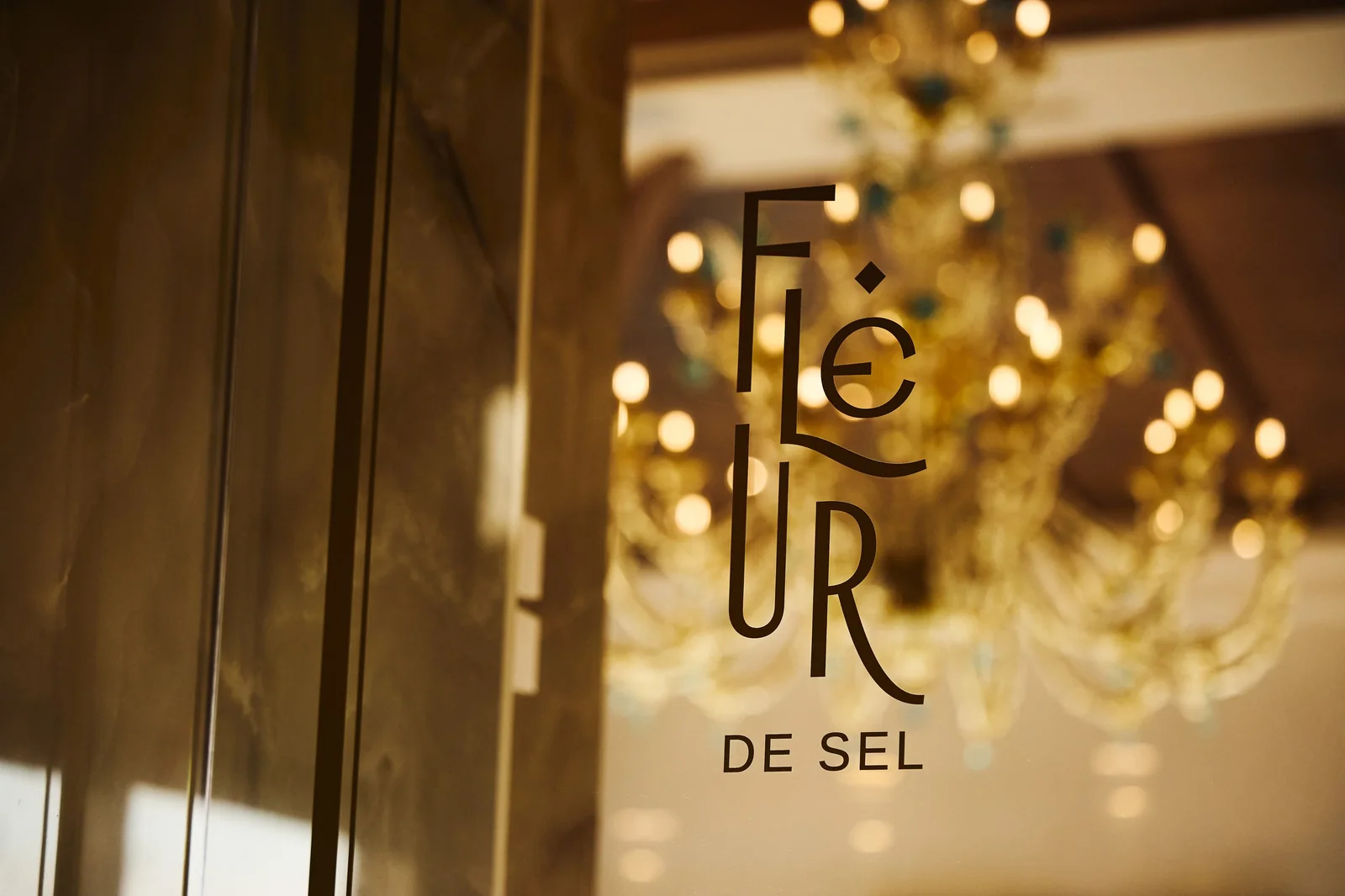 Restaurant name etched on the glass door, brand photography for a fine dining venue