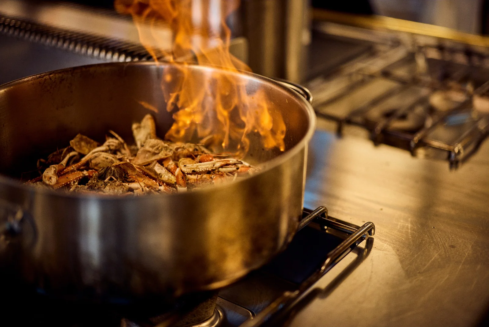 Shellfish flambéed in the kitchen, restaurant photography for a fine dining venue