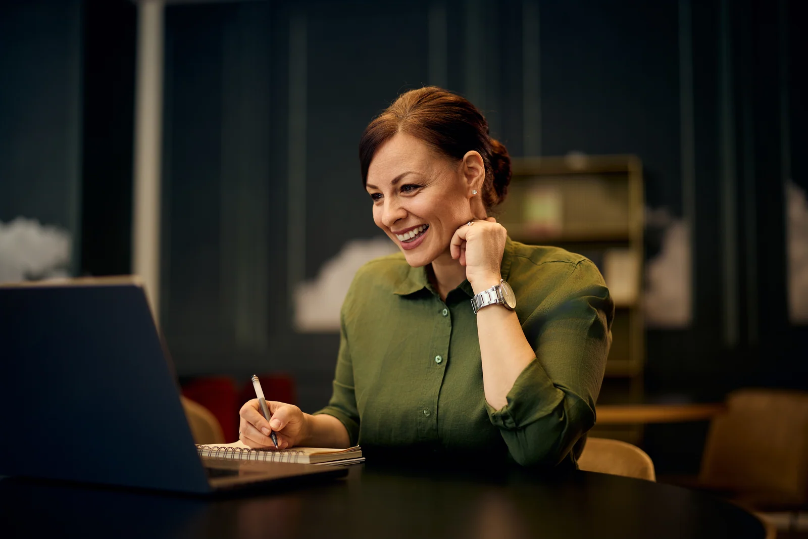 Consultant taking notes during a video call, business portrait for a professional services firm