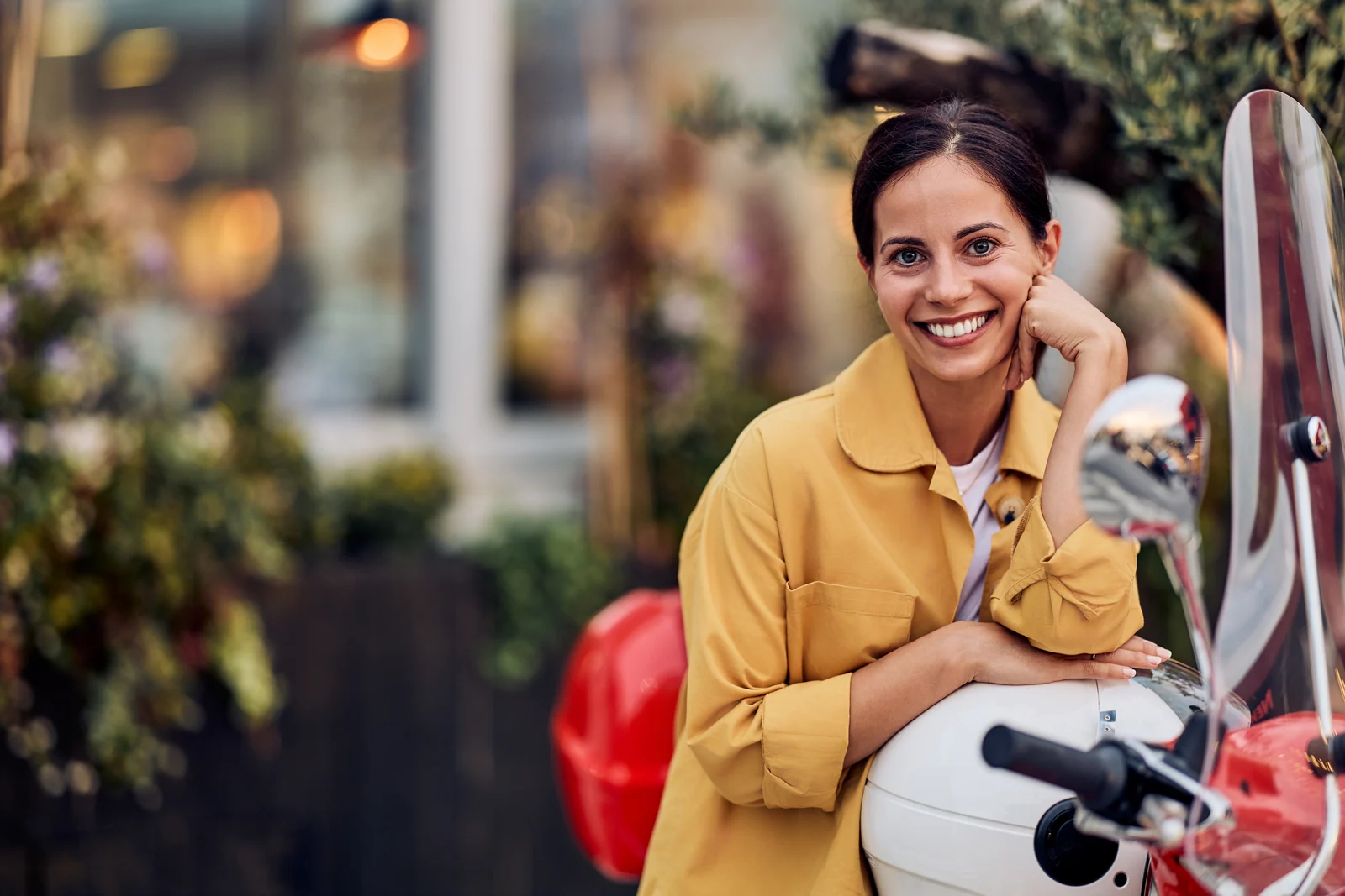 Woman with a scooter outside a shopfront, lifestyle photography for a brand campaign