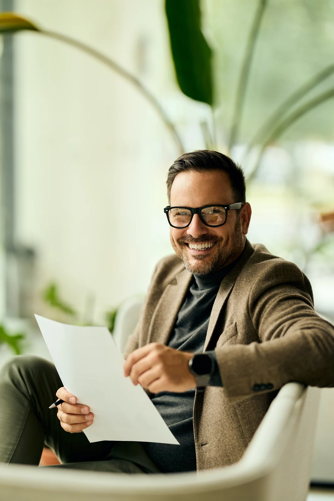 Executive reading a brief in an armchair, business portrait for a professional services firm