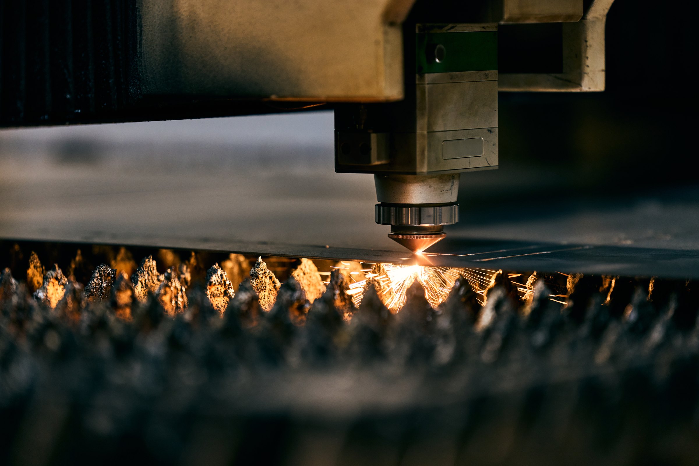 Laser cutter shaping sheet metal in a factory