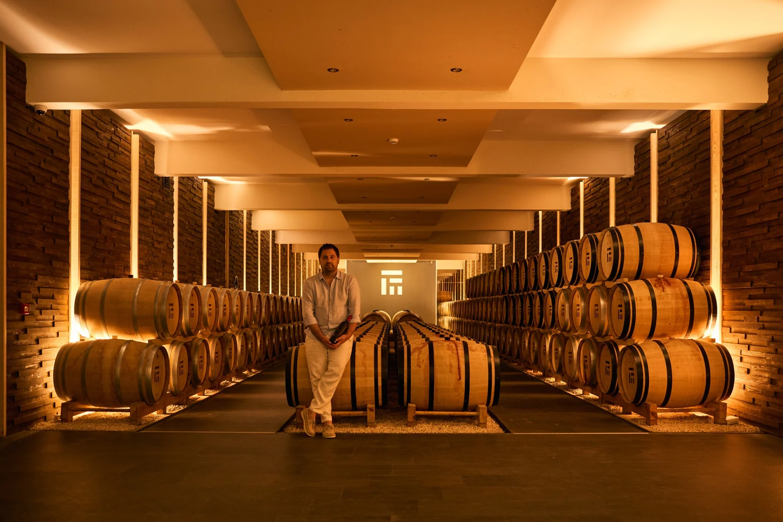 Winemaker in the barrel hall, brand photography for a winery
