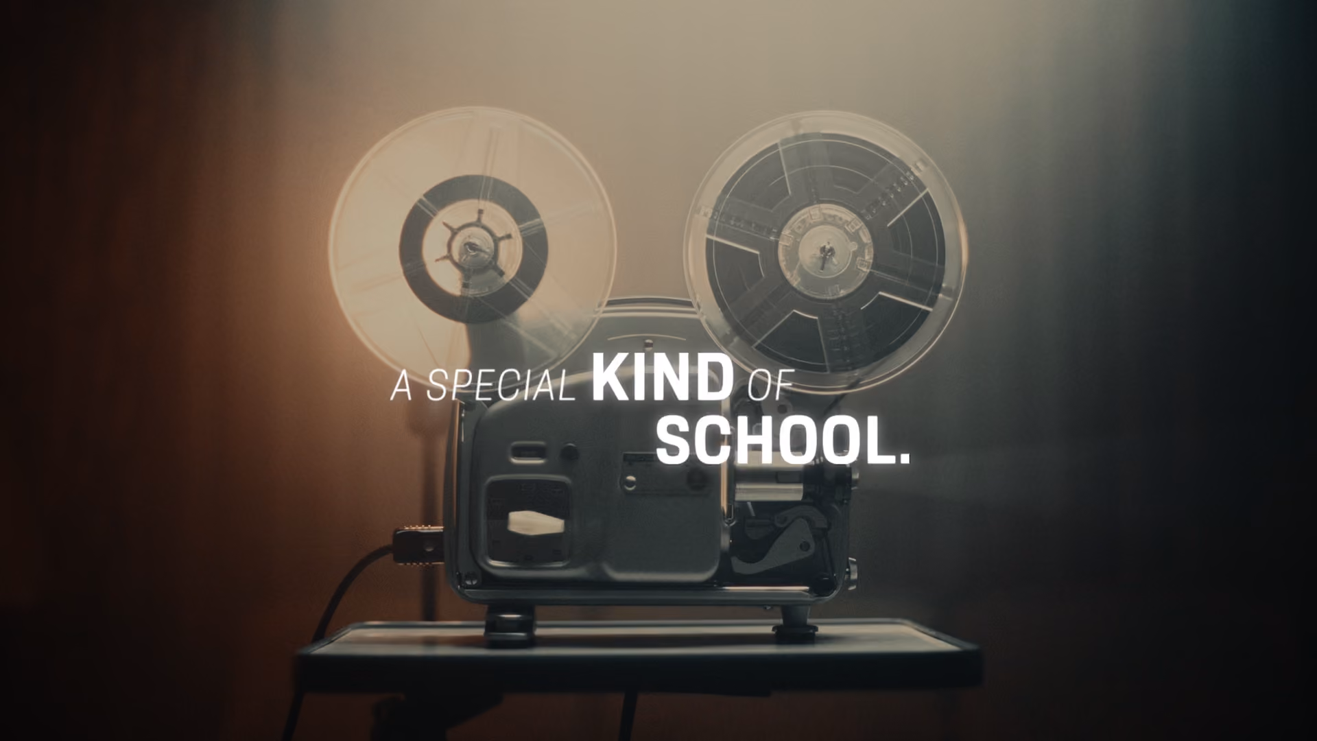 Vintage film projector on a table with the text A special kind of school overlaid.