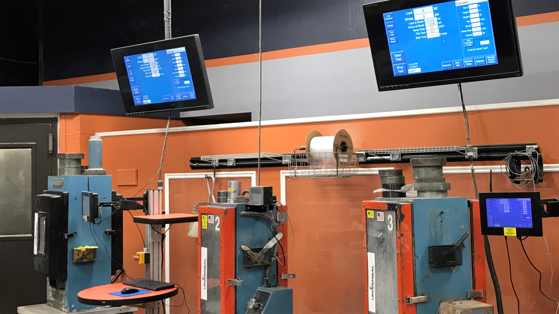 Concrete test cylinder under load in a flat-panel compression breaker