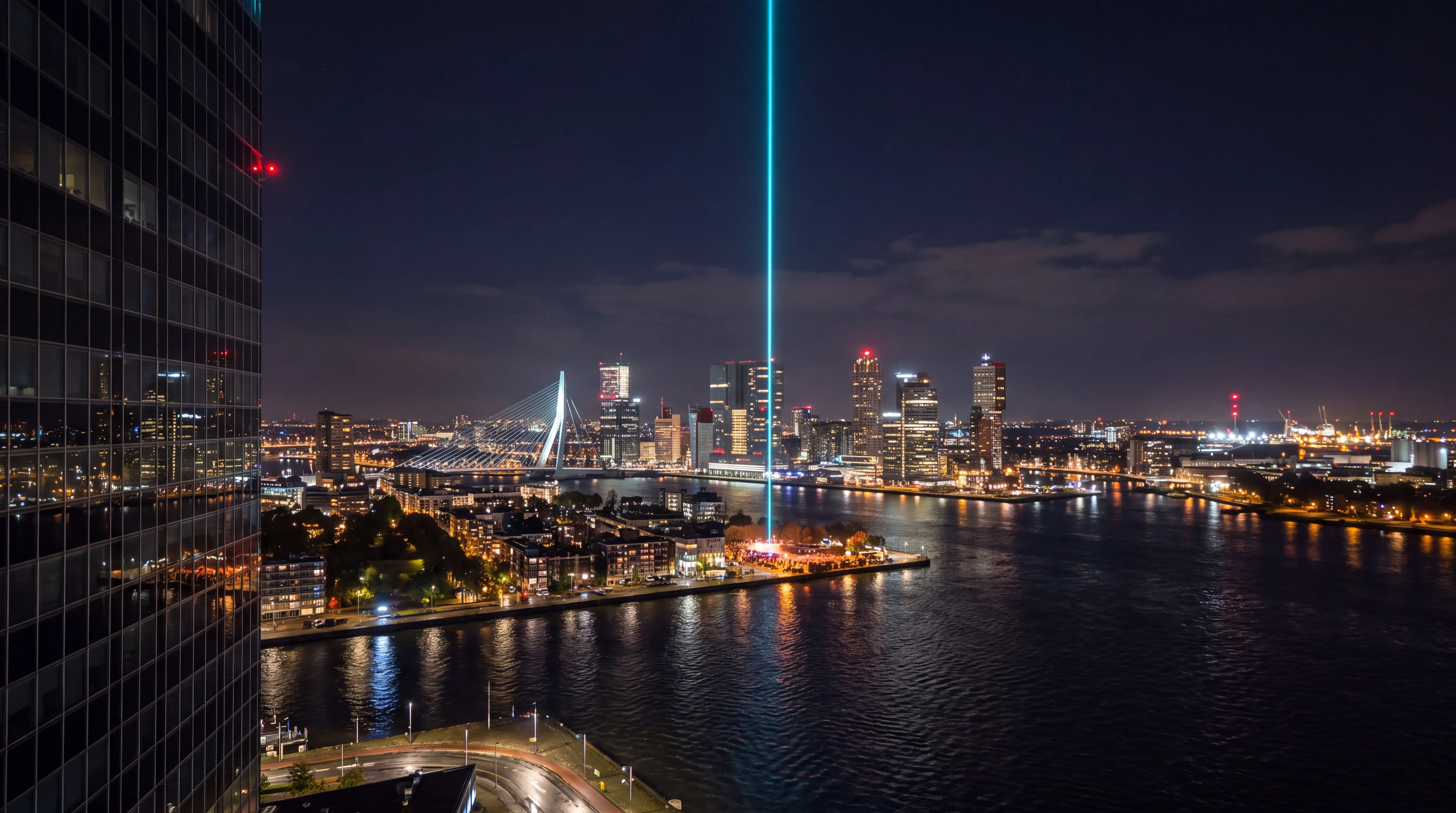 Large outdoor event marked by a vertical sky laser over Rotterdam