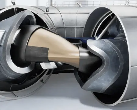 A render of Alpha, a net-energy-gain fusion demonstrator based on stellarator technology. The object is in a large room and has a donut-like metal shell. 