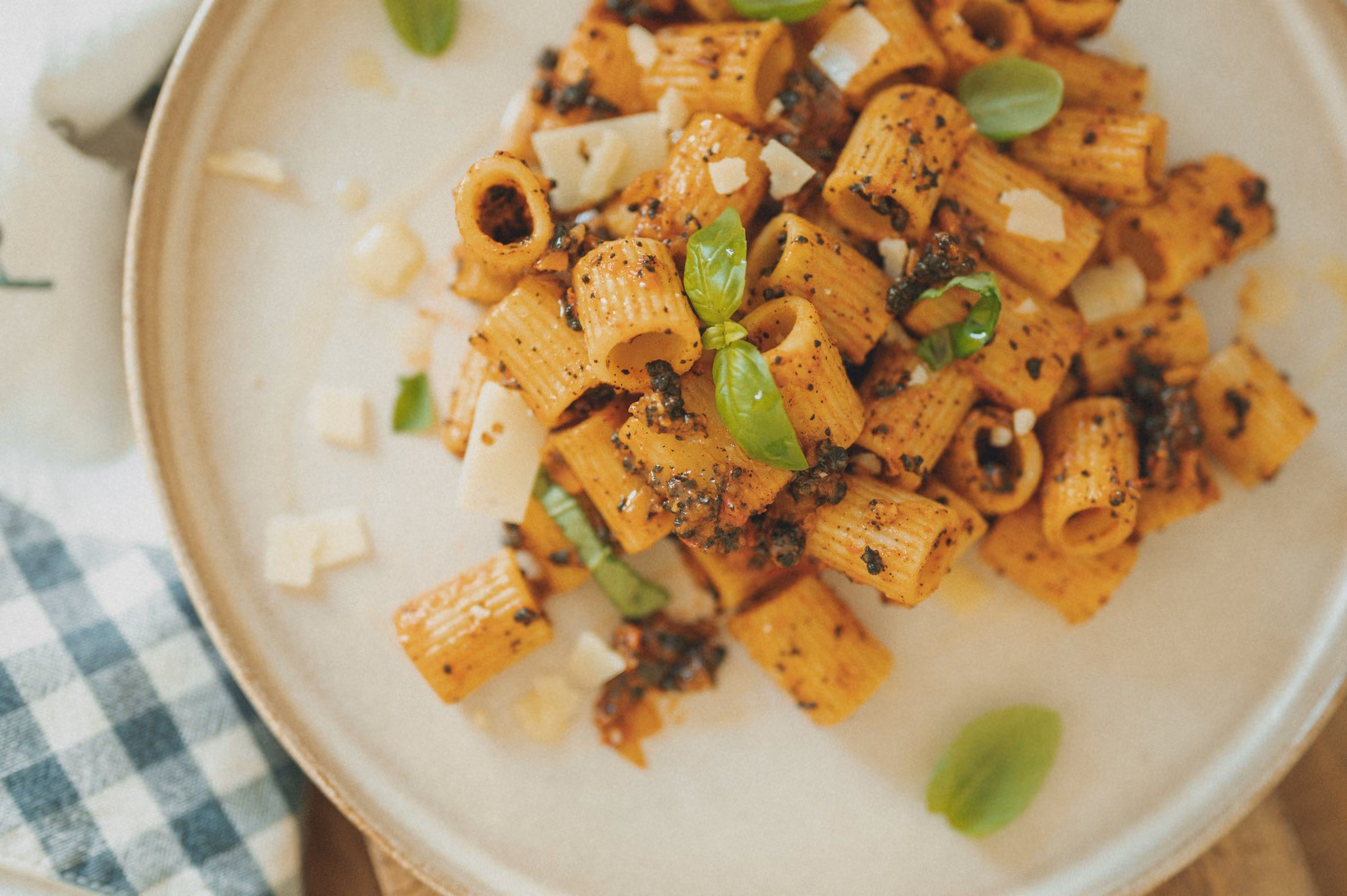 Assiette de rigatoni à la sauce tomate-basilic, sur une nappe à carreaux