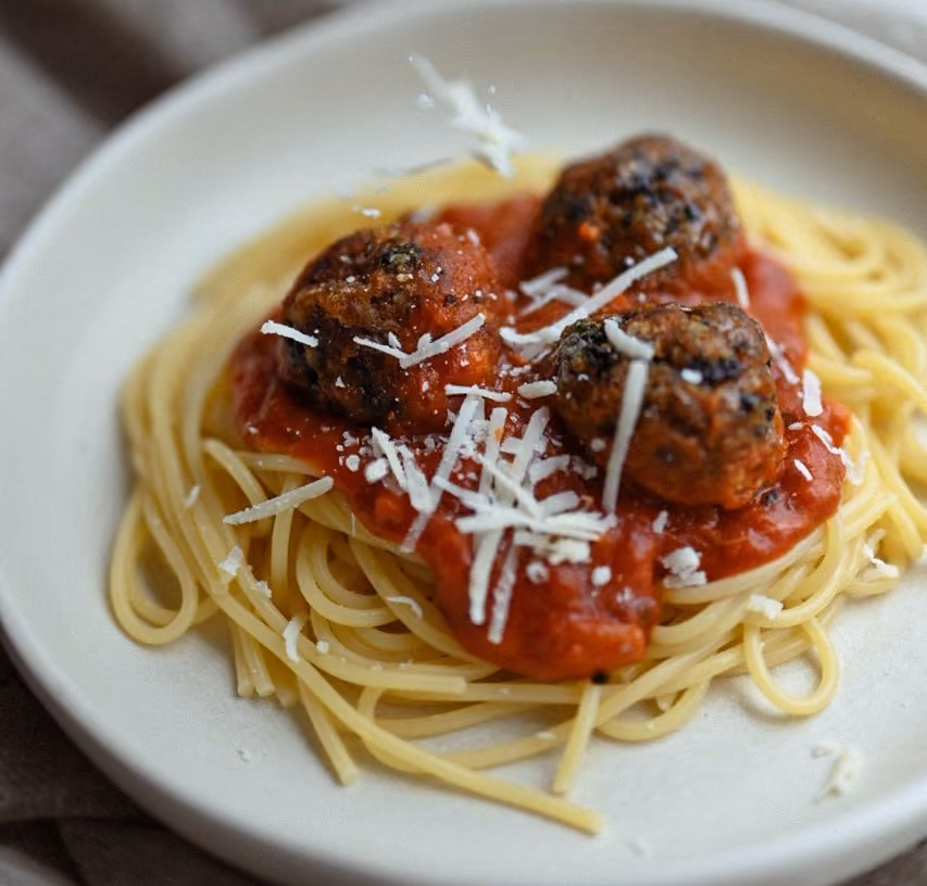 Assiette de spaghetti à la sauce tomate garnie de trois boulettes végétales Edo et de parmesan râpé