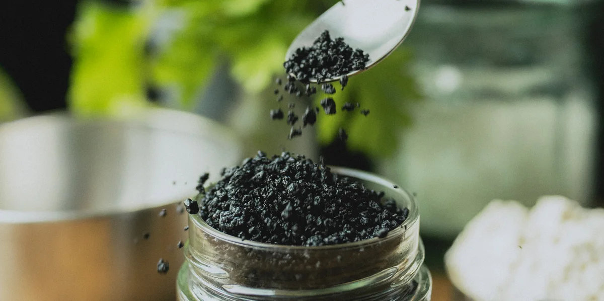 Granulés protéinés lyophilisés versés à la cuillère dans un bocal en verre