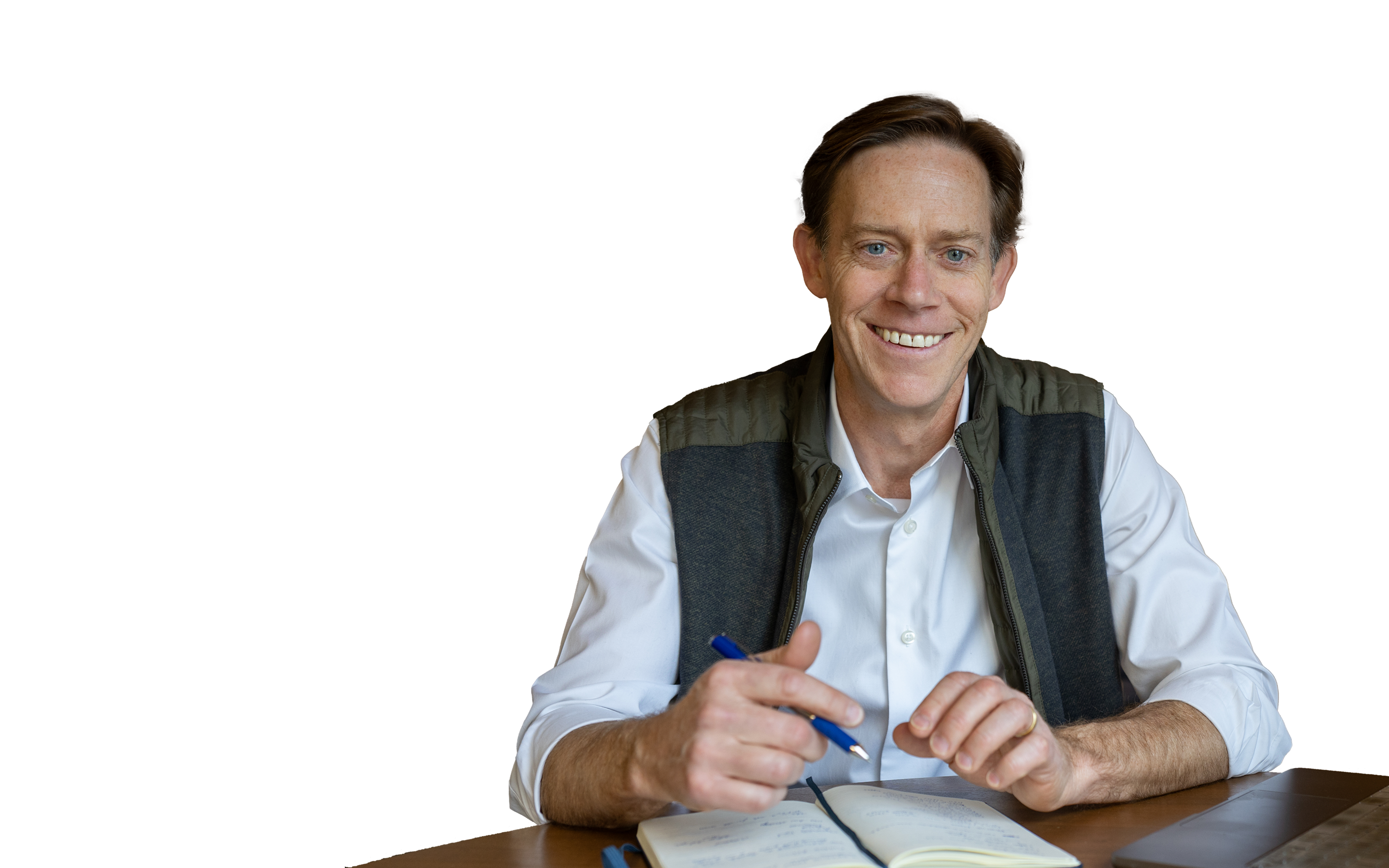 Chad Eckes seated at a wooden desk with a notebook