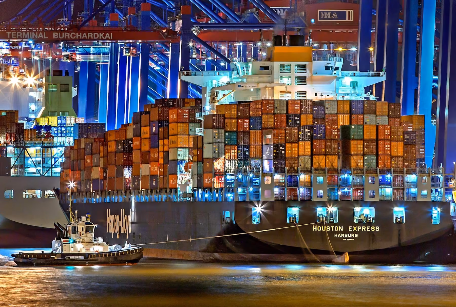 Container ship Houston Express of Hamburg loaded with colorful containers at night in port.