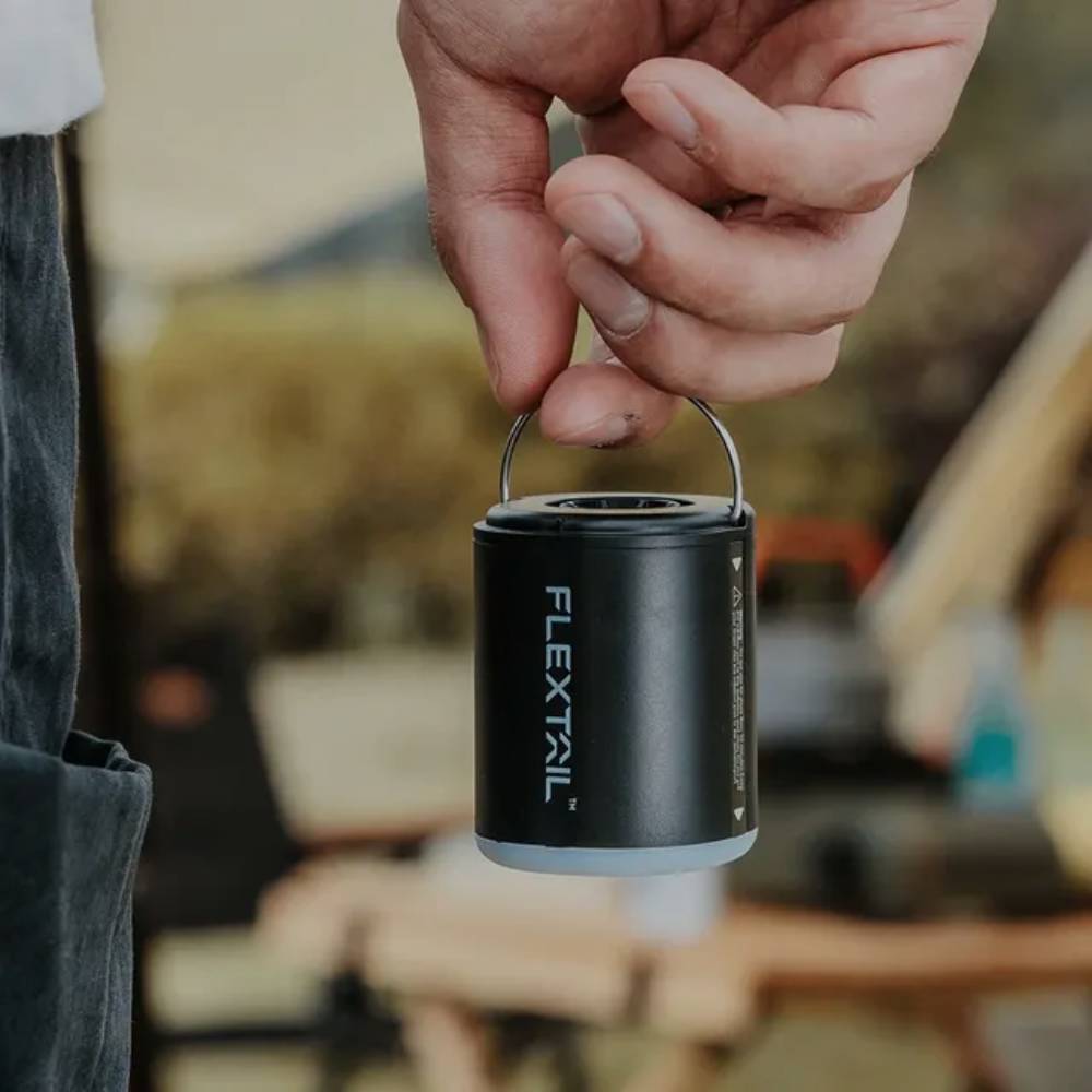 Two sleek PLAUD wireless speakers, one black and one gray, side by side on a gray background.