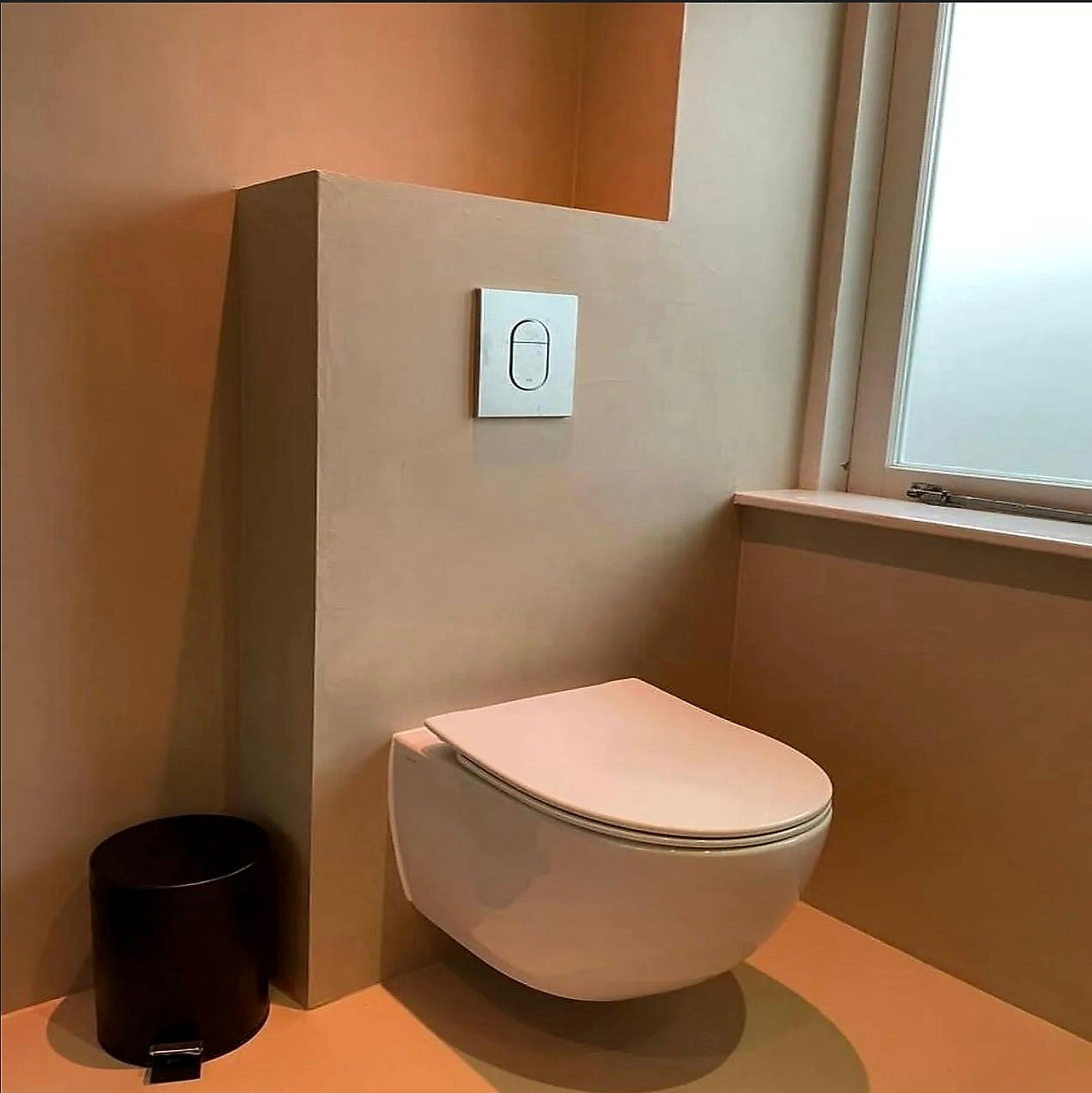 Warm wall finishes around timber and brass bathroom fittings
