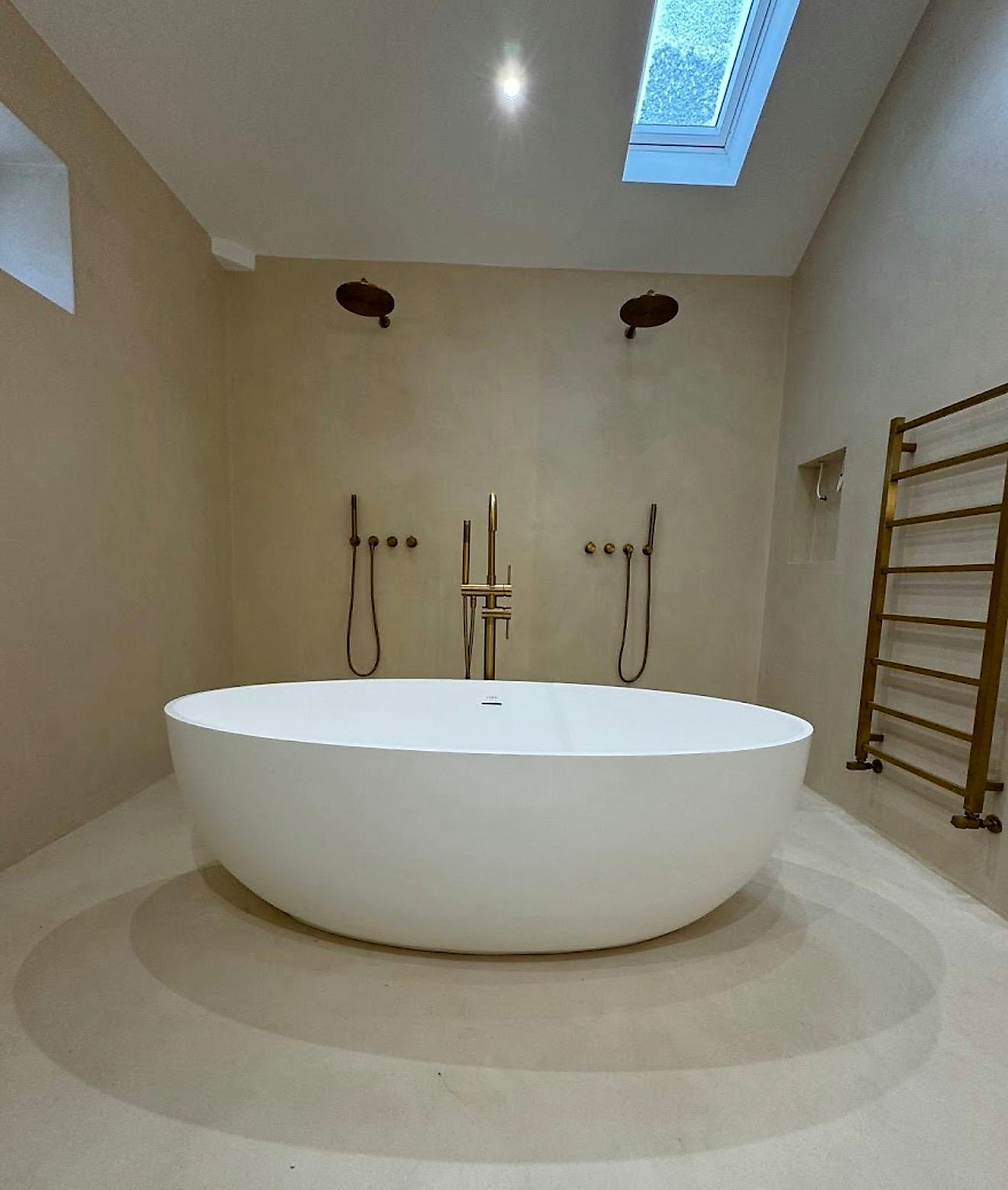 Basin and brass tap against a soft neutral surface
