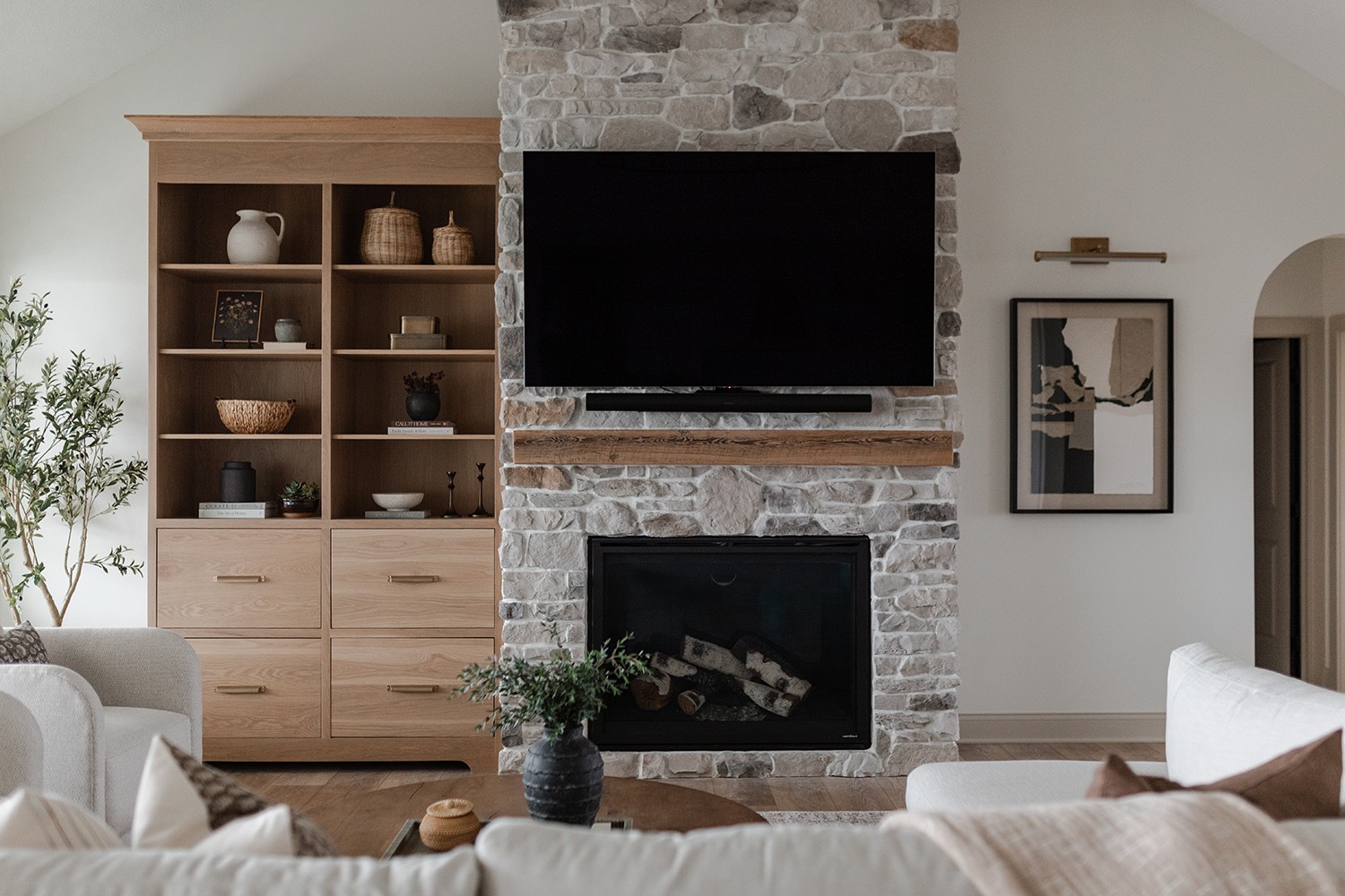 Living room with stone fireplace and white oak built-ins