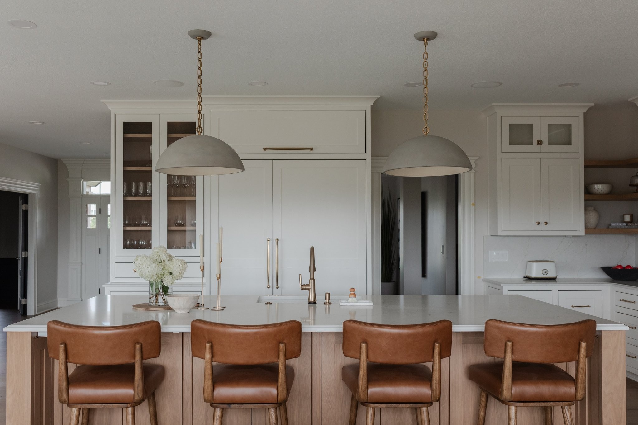 Kitchen with island seating and brass pendants