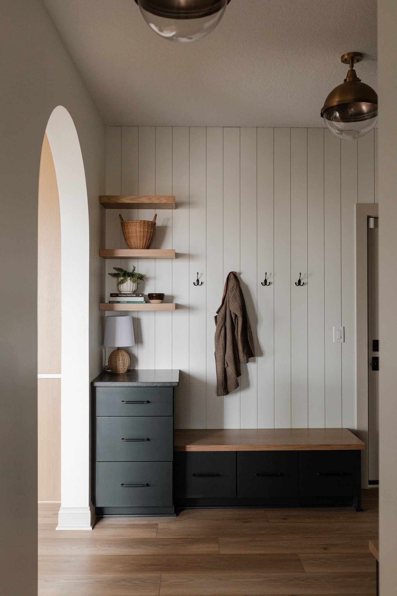 Mudroom with shiplap, oak bench and brass fixtures