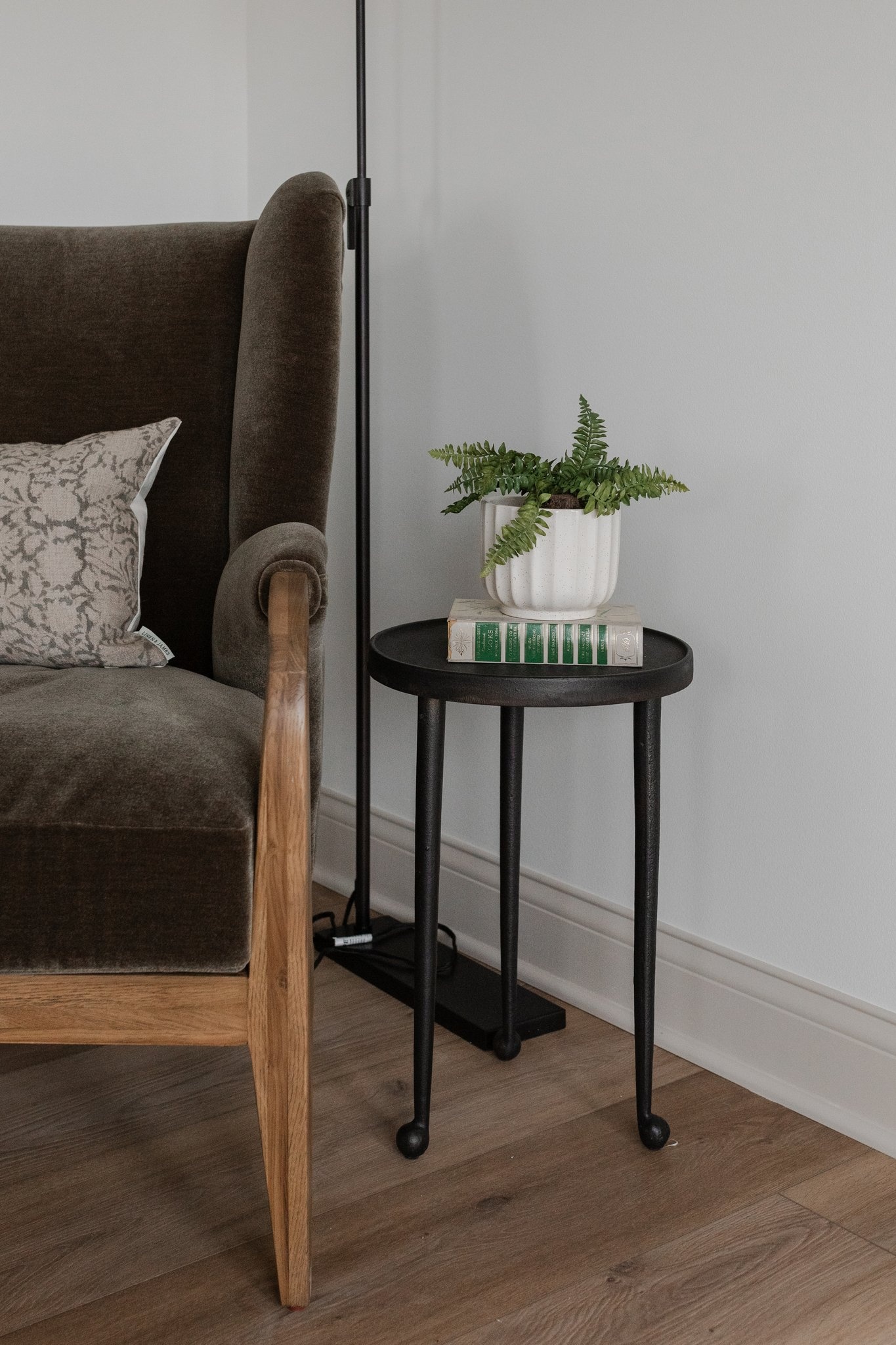 Sitting corner with upholstered chair and potted fern