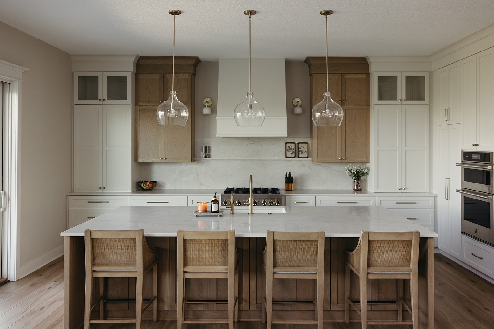 Kitchen island with cane stools and glass pendants