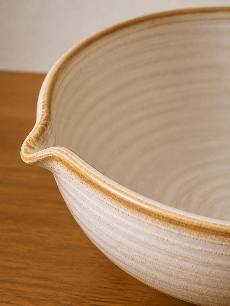 Ivory glaze, warm rim and the shaped pouring lip seen in close detail