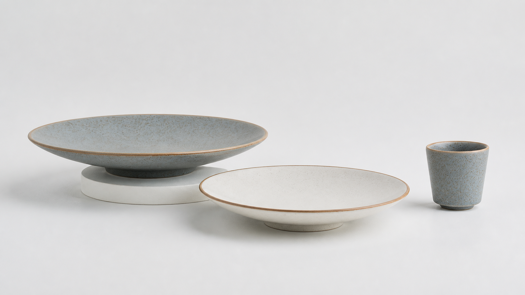 Hearthline collection in Smoke Grey and Warm White: deep serving plate, dinner plate and tea tumbler
