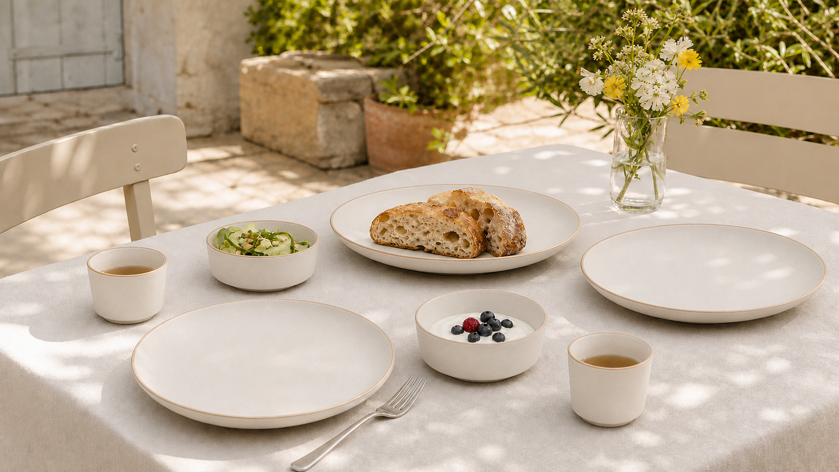 Hearthline Warm White tableware in a realistic garden dining setting