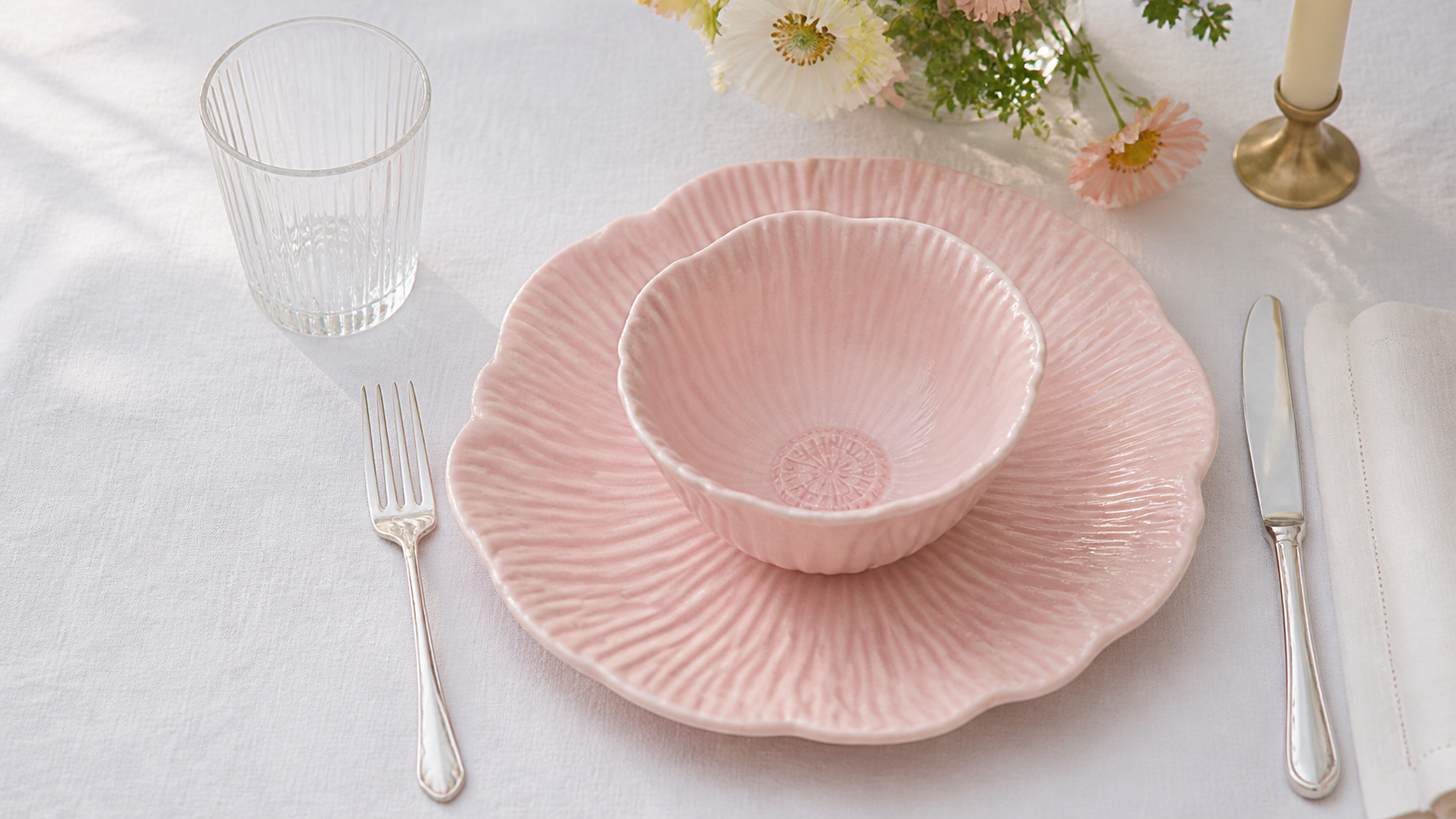 Close overhead view of a Fine Rim blush pink bowl and plate with radiating petal relief