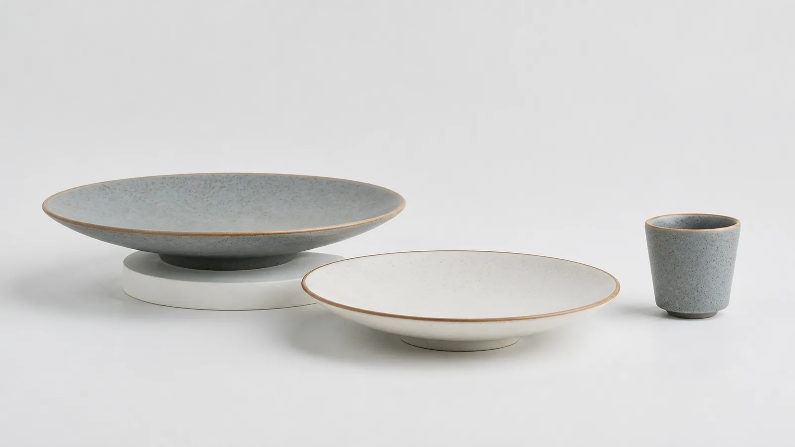 Hearthline collection in Smoke Grey and Warm White: deep serving plate, dinner plate and tea tumbler