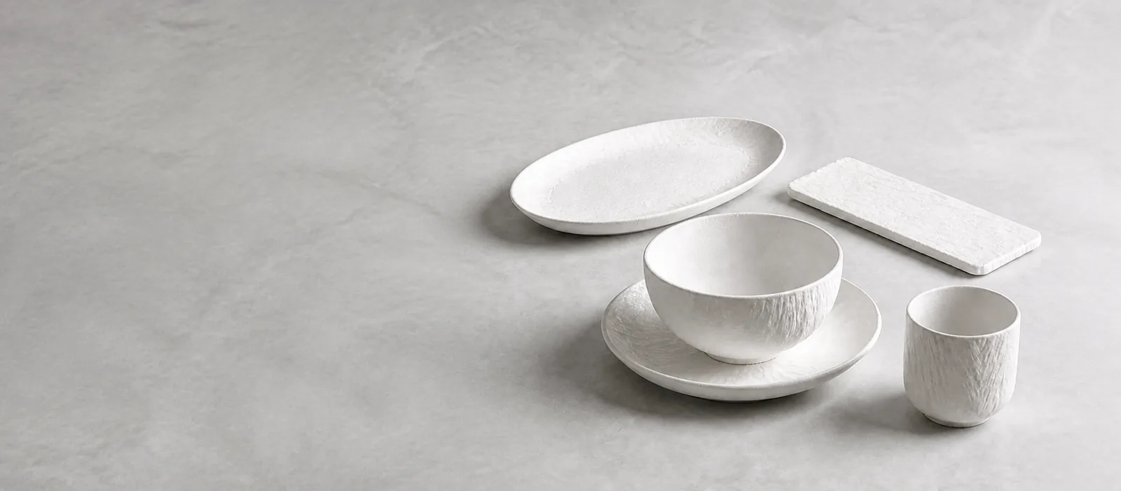 Chalk Strata approved collection visualization: five coordinated ceramic forms on a cool neutral surface