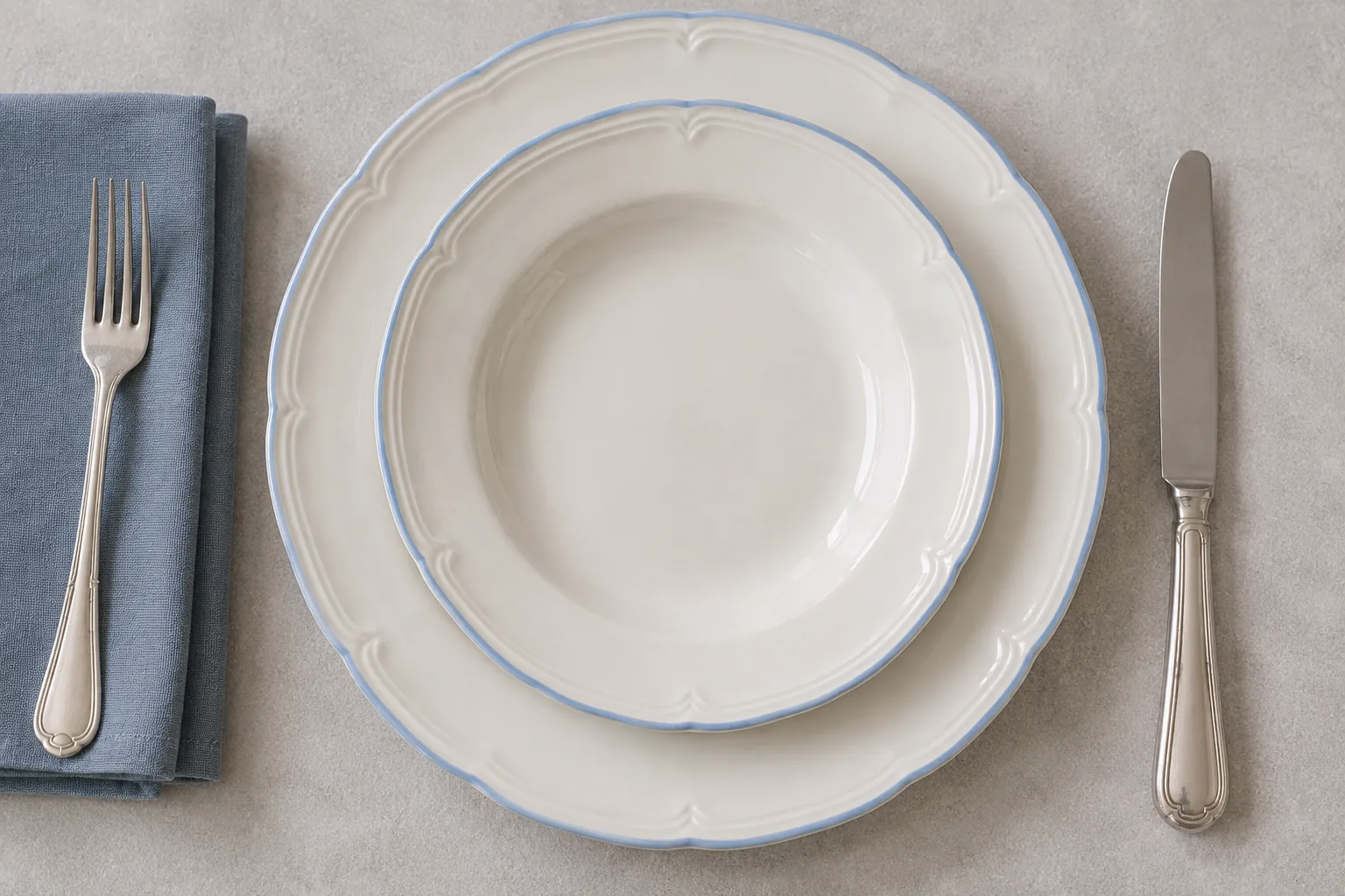 Overhead Meadow Sprig plate setting with scalloped blue rims and silver cutlery