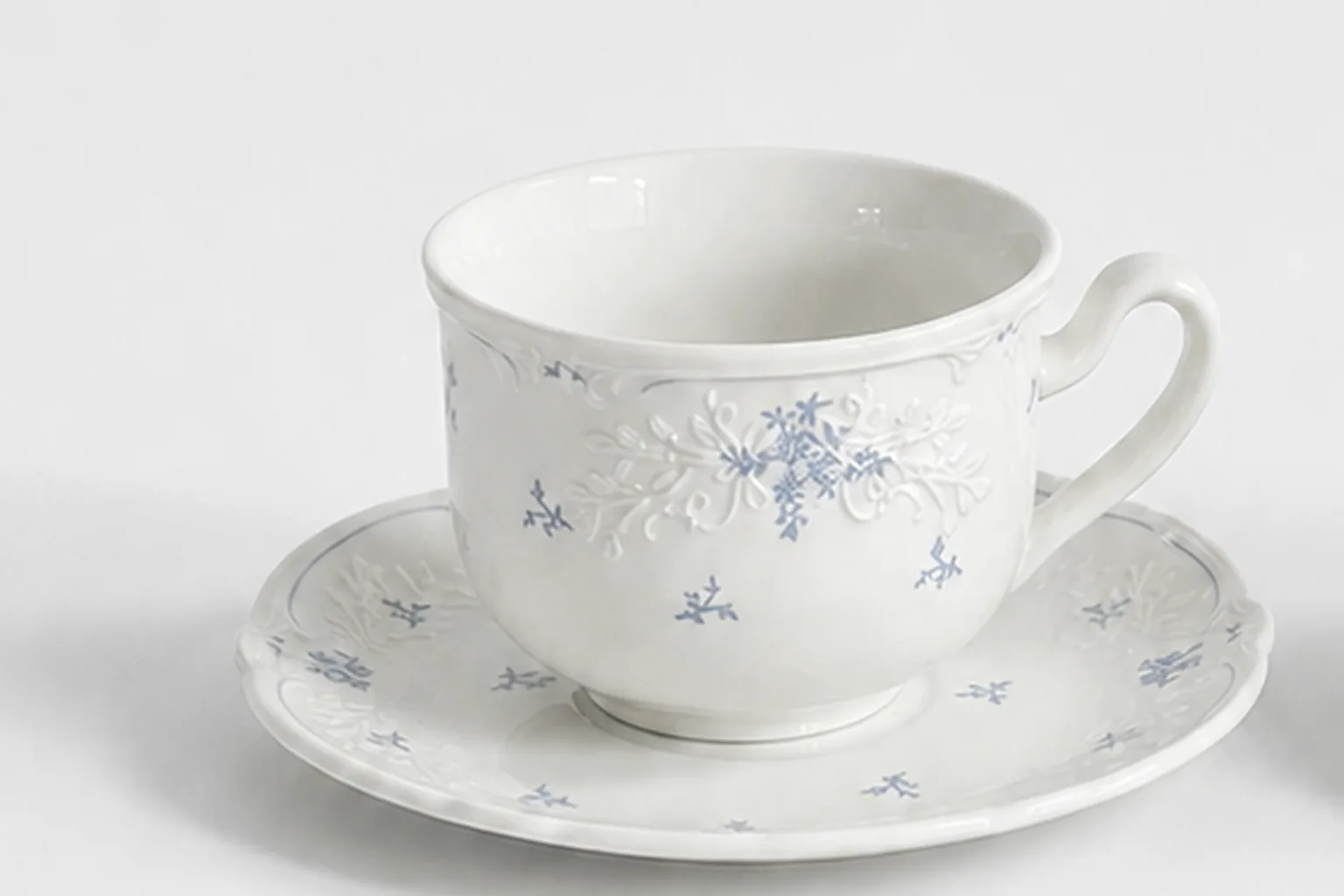 Close view of the embossed floral detail on a Sculpted Petal cup and saucer