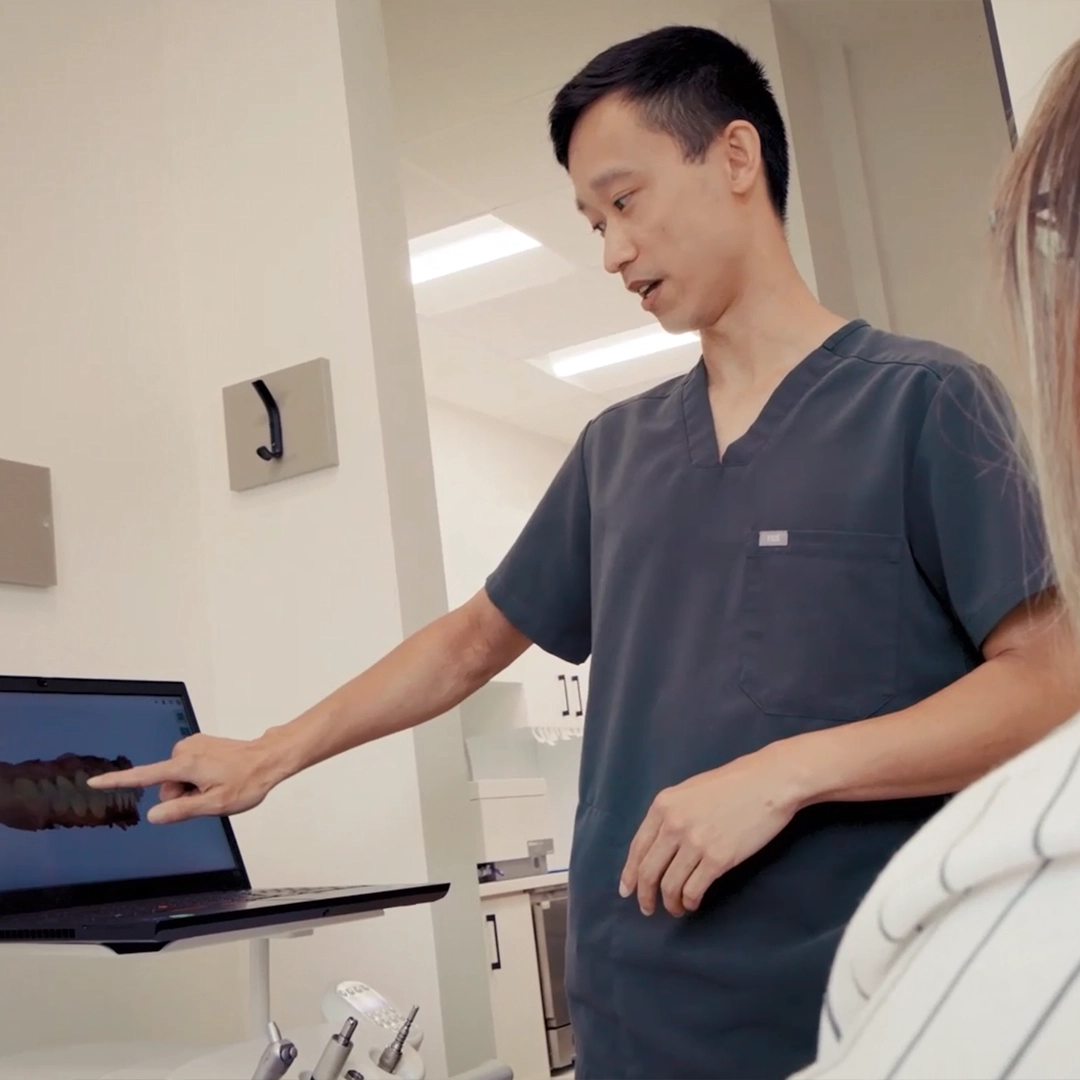 Dentist showing a patient a digital scan of their teeth on a laptop at Family Dental Care Cayuga