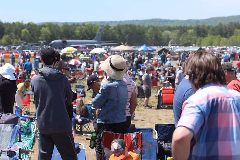 group of people watching planes fly at air show