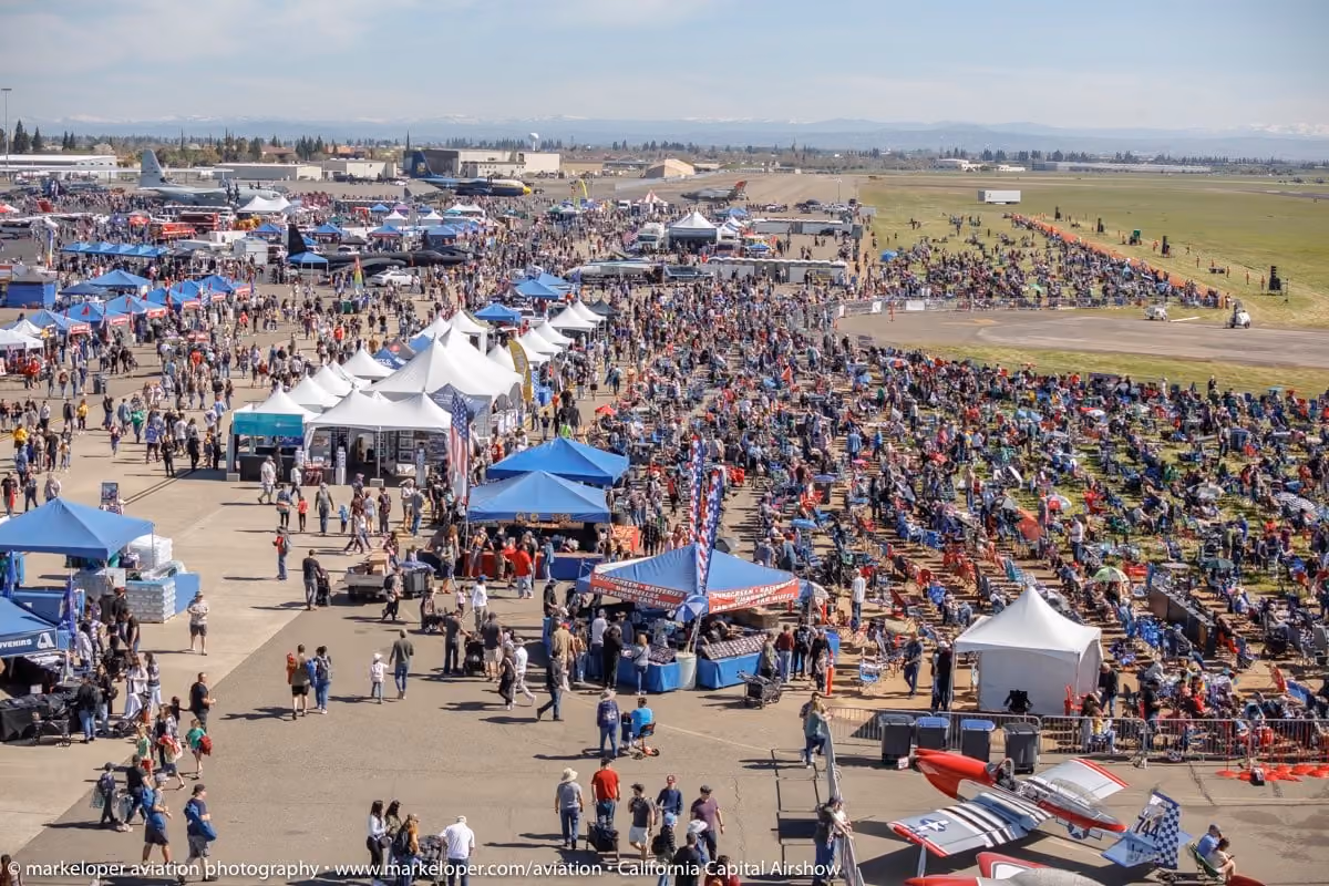 large group of people on tarmac at air show