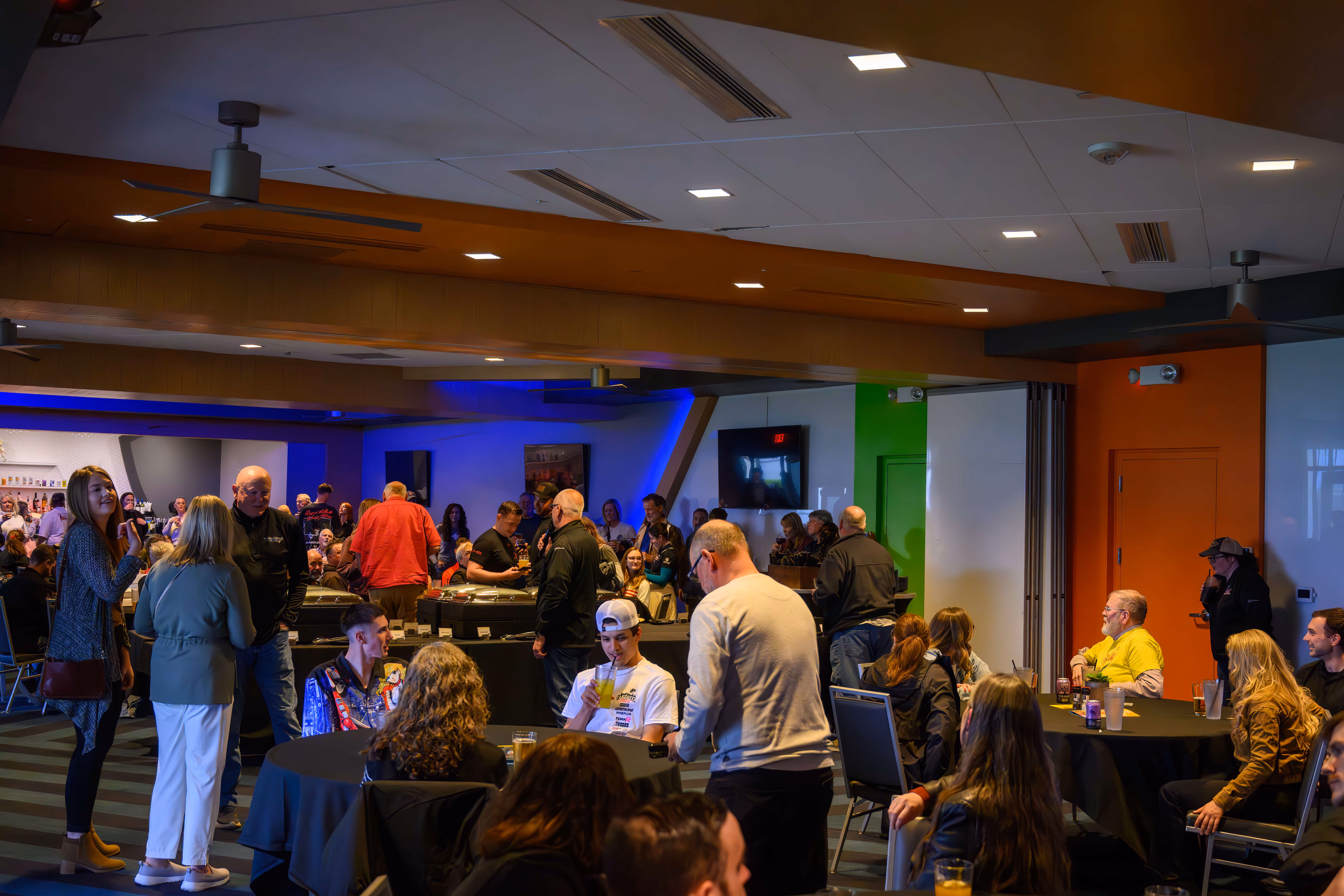 group of people gathered around tables in large room