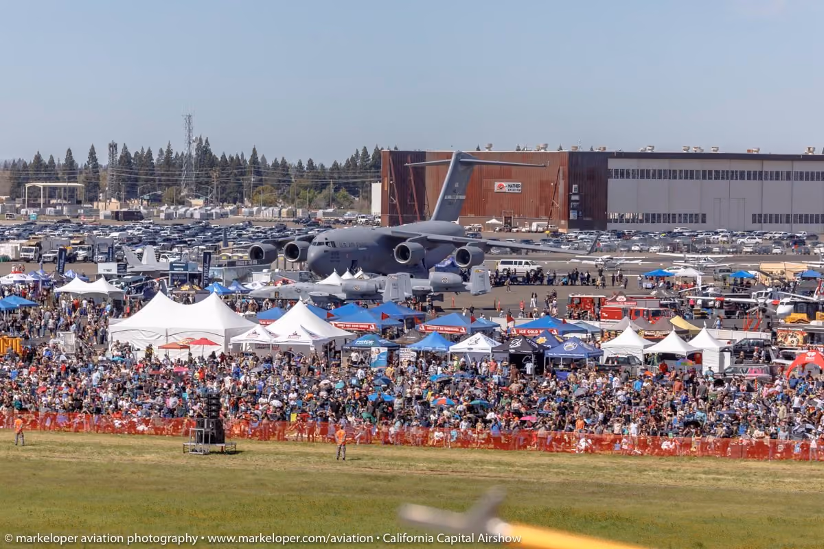 large crowd of people in front of a plane at an air show