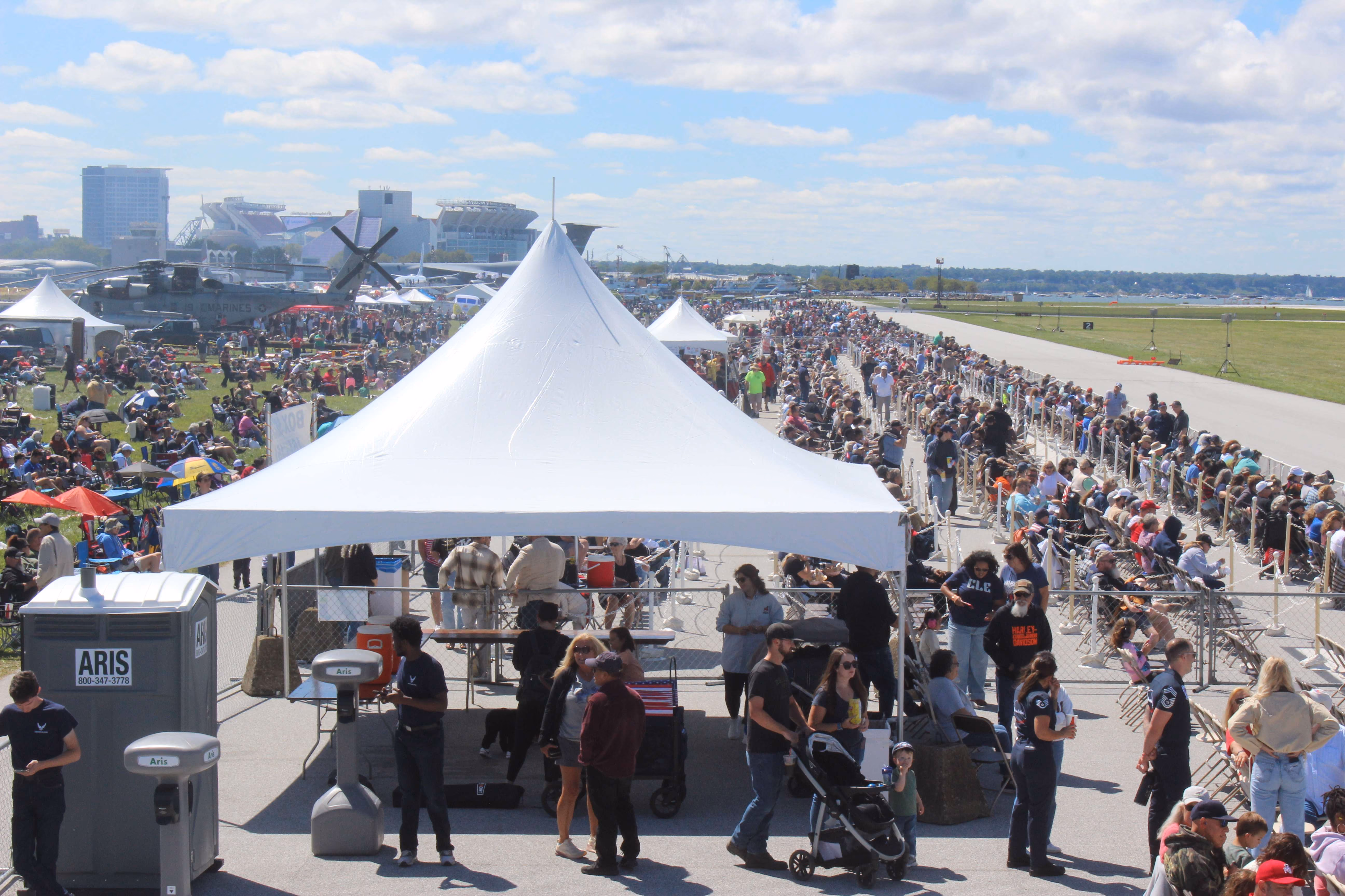 white tent with large group of people around it at air show