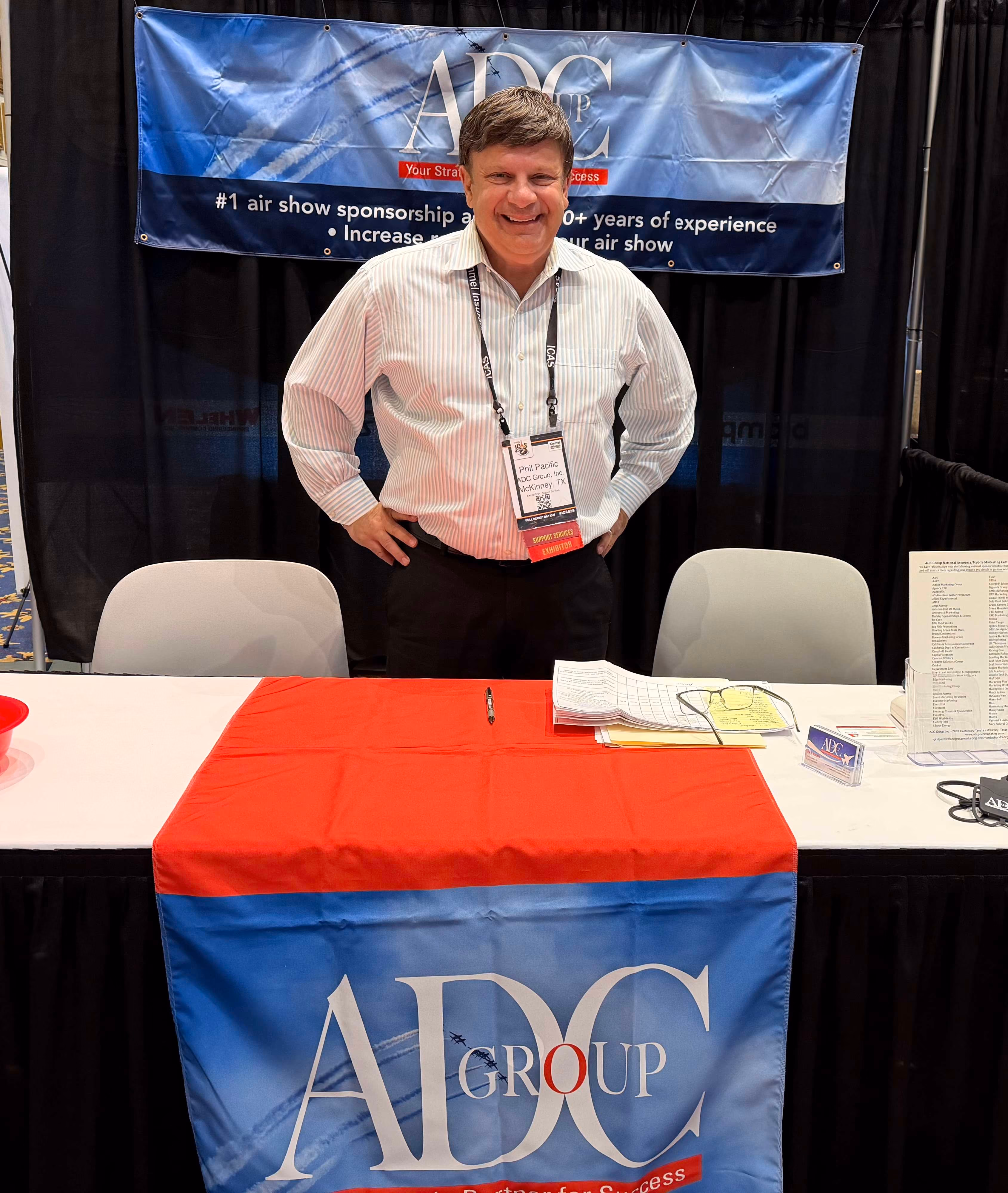 Phil Pacific owner of ADC Marketing Group standing behind marketing display table