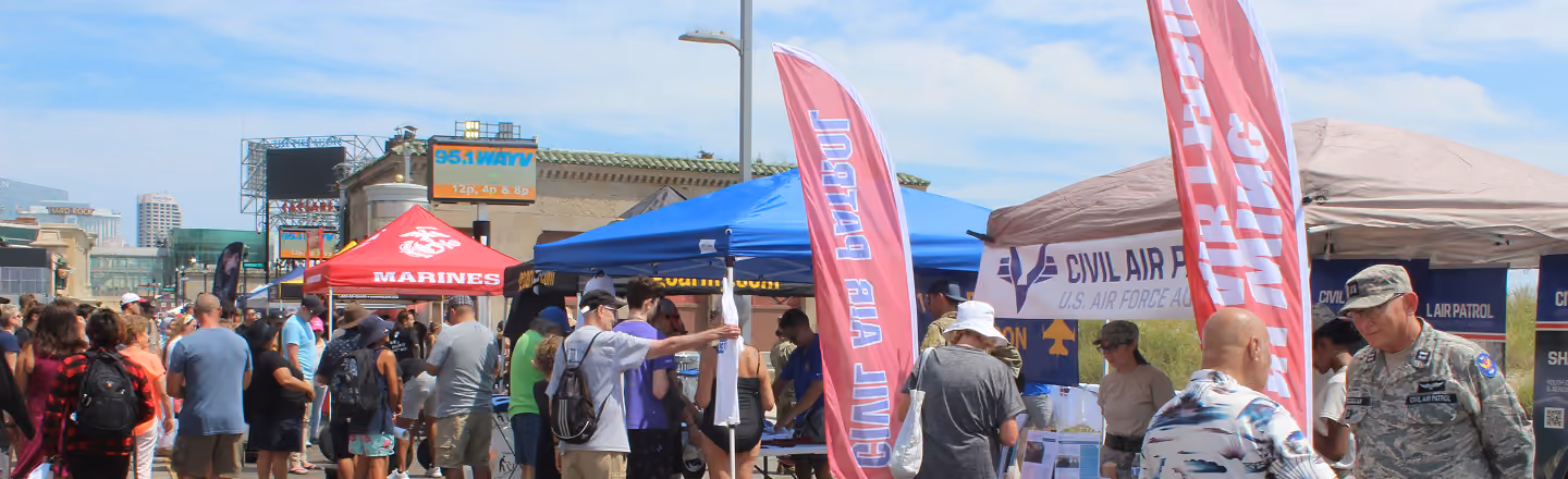 large crowd of people in front of marketing tents at air show